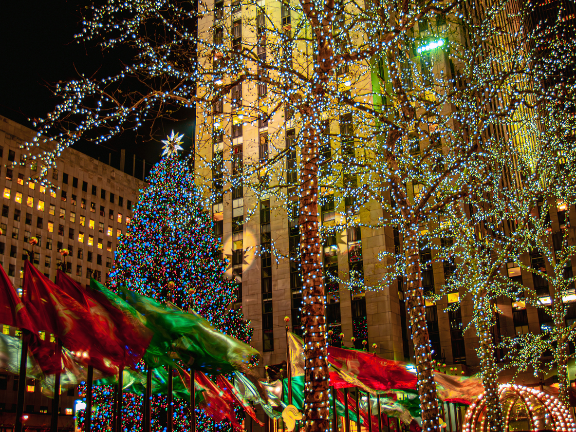 Holiday flags and the Christmas tree on a windy night in Rockefeller 
